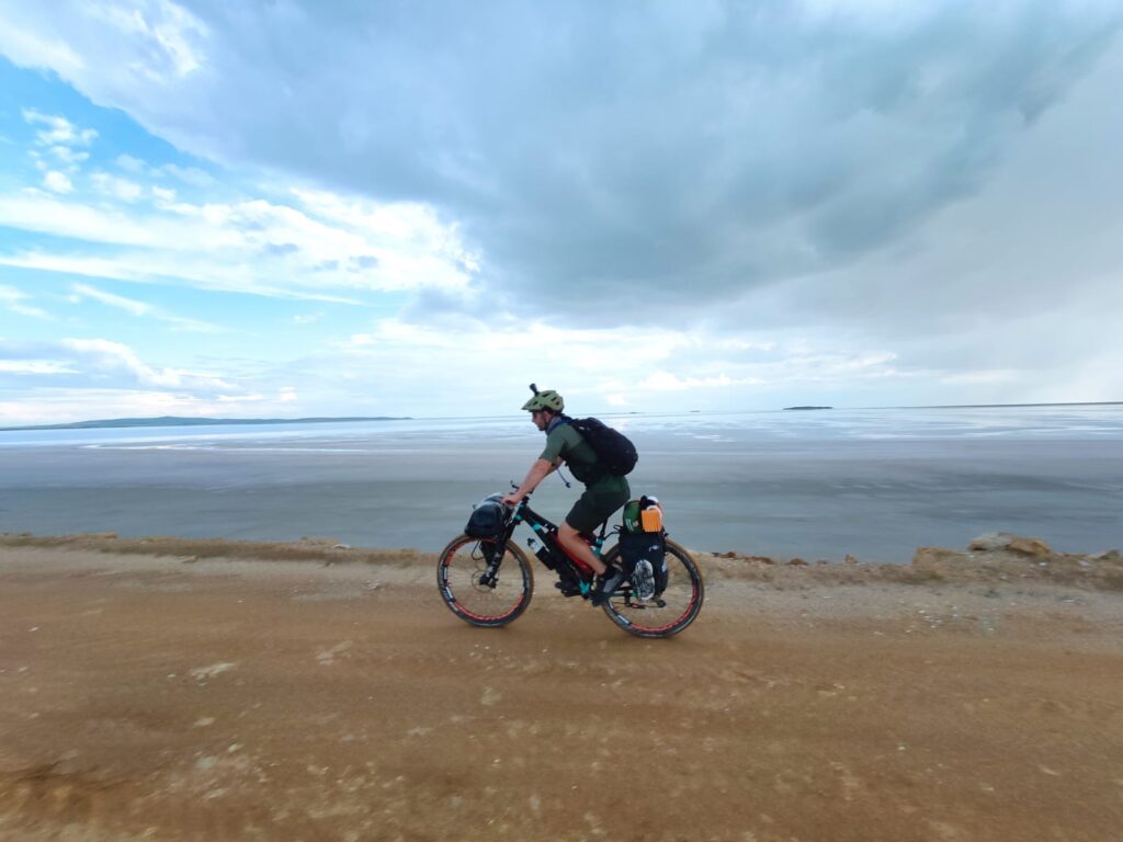 Cyclist riding through Tuz Gölü, Turkey's vast salt lake, during a bikepacking expedition.